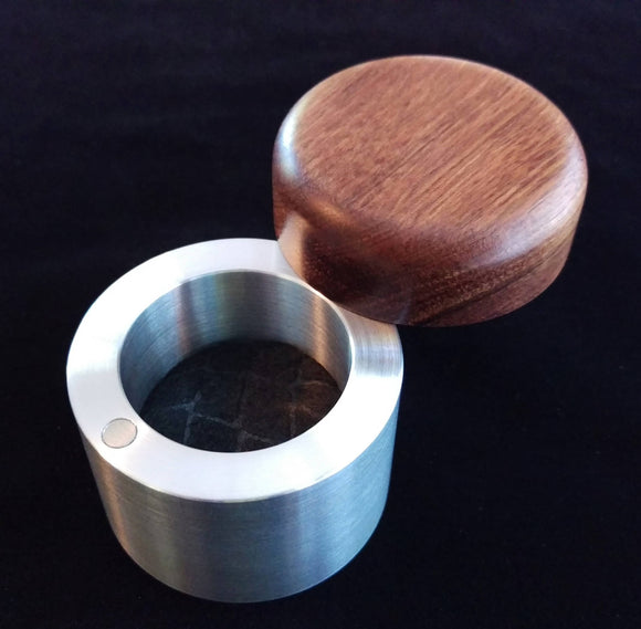 cylindrical engagement ring box, with silver metal base and reddish brown wooden lid, black felt inside