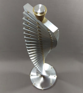 Silver metal sculpture with brass details, arranged in a spiral