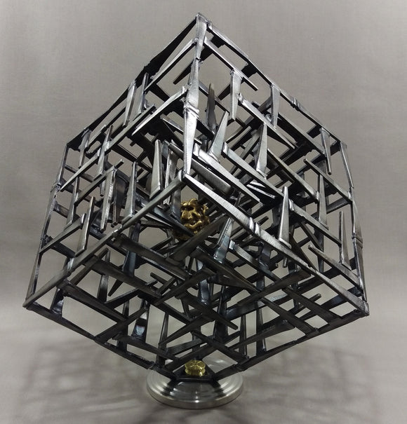 Cube Sculpture made of welded angled black nails, brass brain trapped inside a mesh of nails