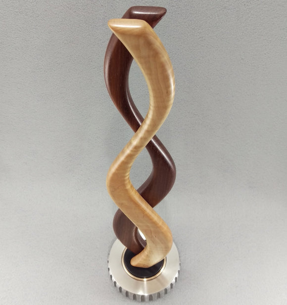 small tabletop sculpture with red and white wood, silver metal base with bronze and black inlays
